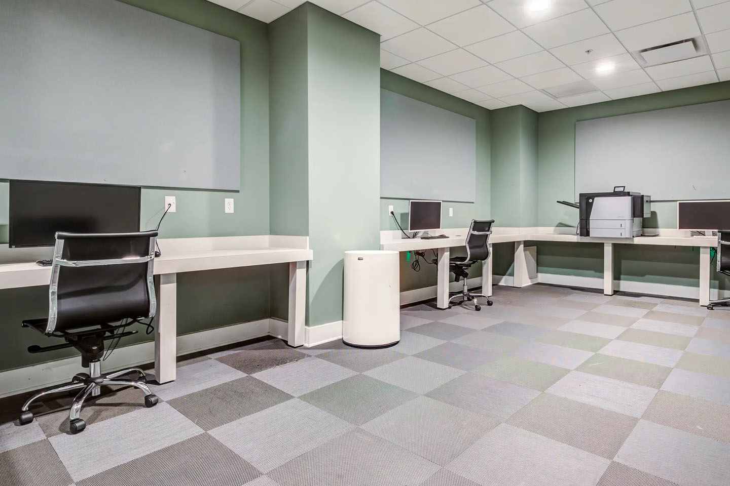 Apartment complex study facility with desks and desktop computers.