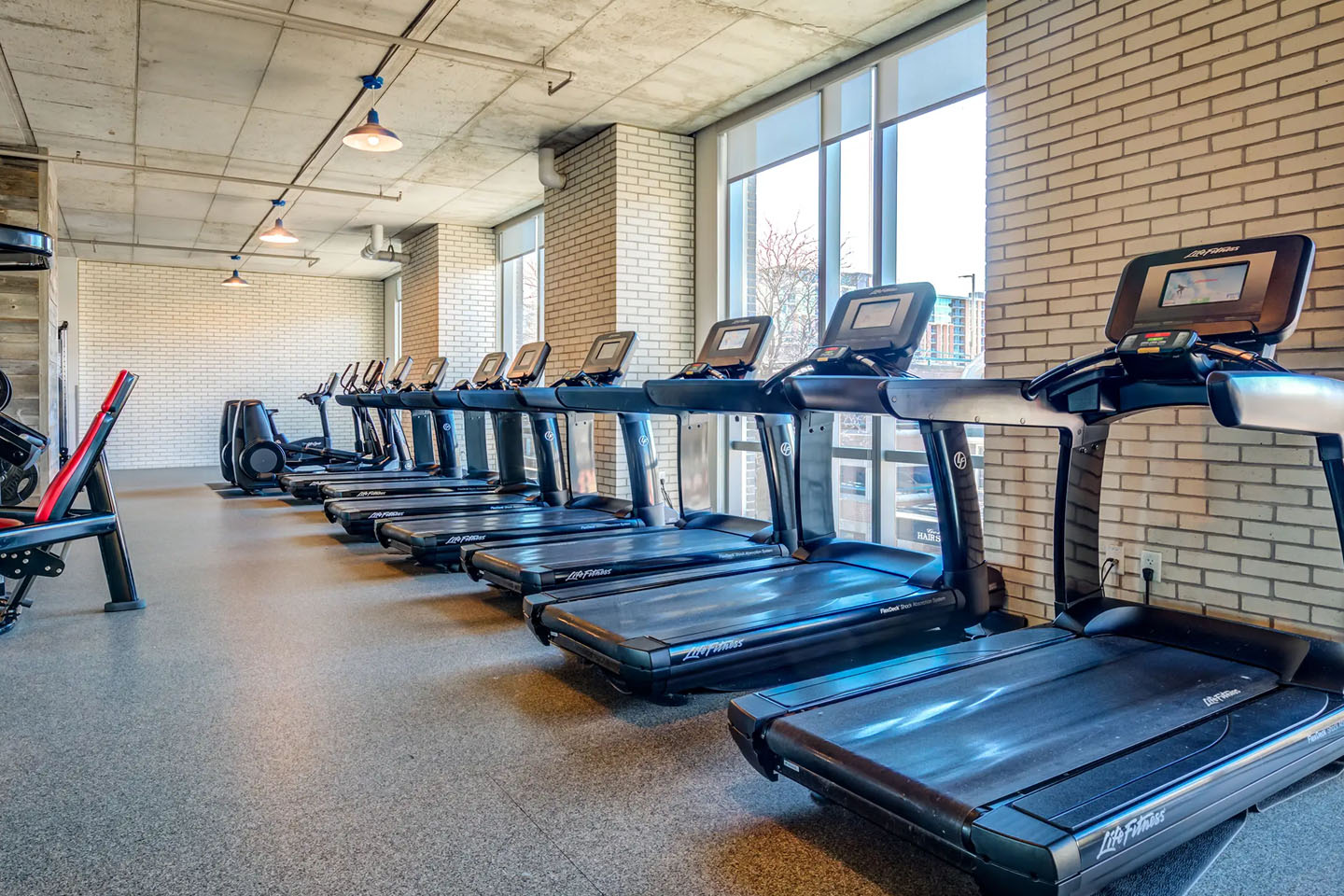apartment complex gym with a line of treadmills
