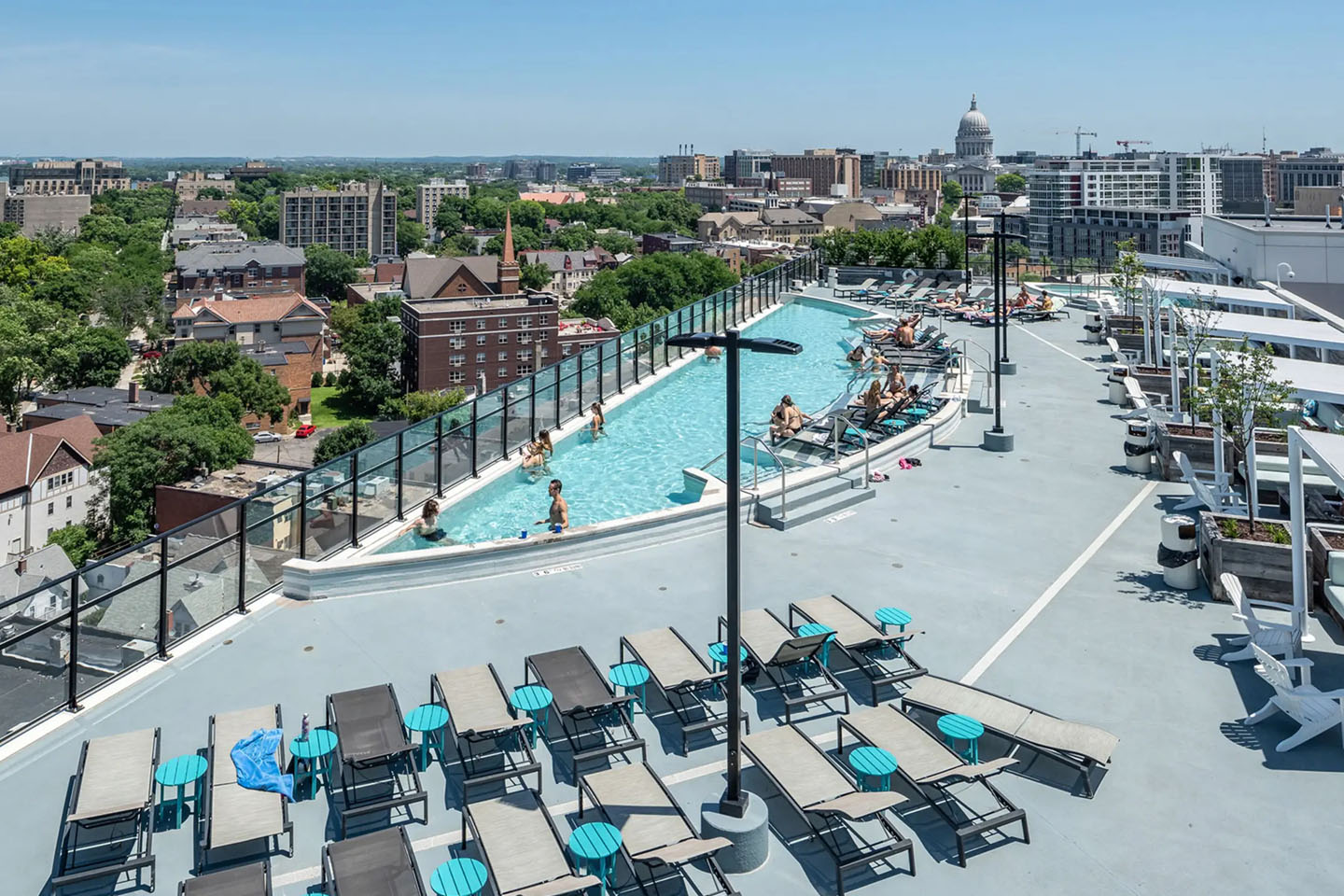 Rooftop pool with lounge seating and a view of the city